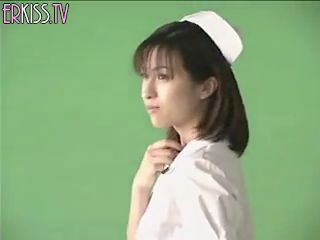 Een jonge Japanse vrouw in verpleegstersuniform poseert voor de camera
