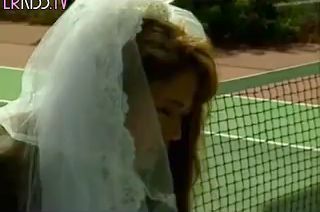 An Asian girl in a bride's dress is fucked on the tennis court